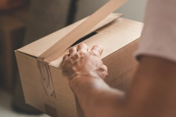 Person klebt Karton zu